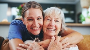 Happy medical professional hugging an elderly woman